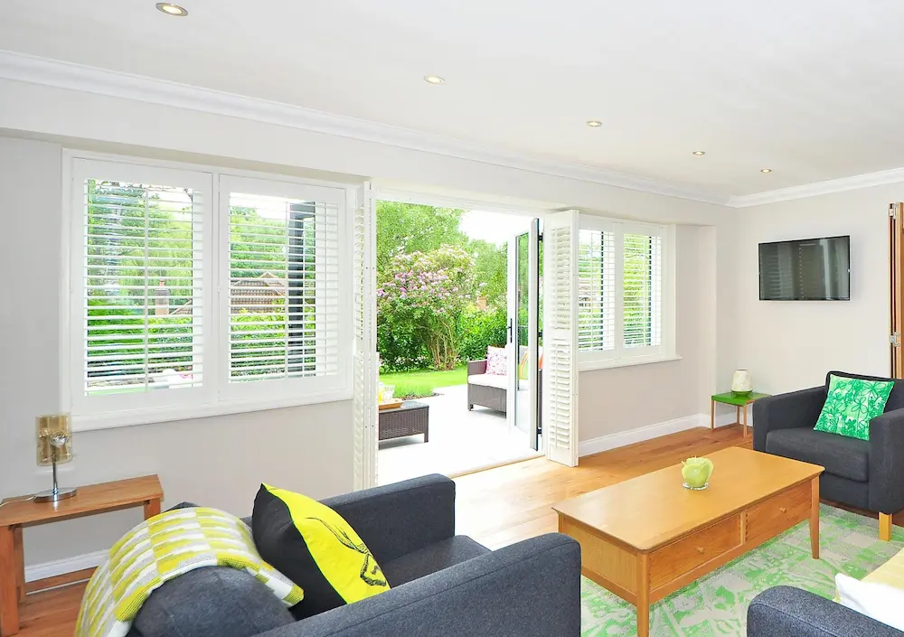 Living room with French doors open to garden patio