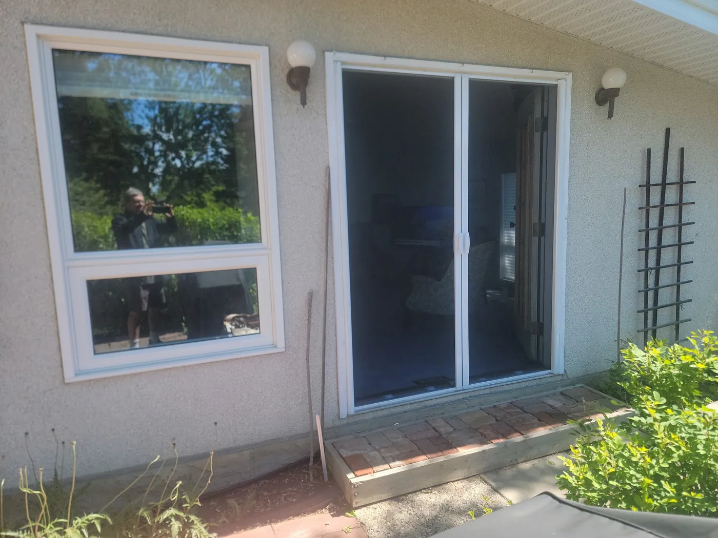 Mirage retractable screen extended across a white sliding patio door on a stucco Edmonton home